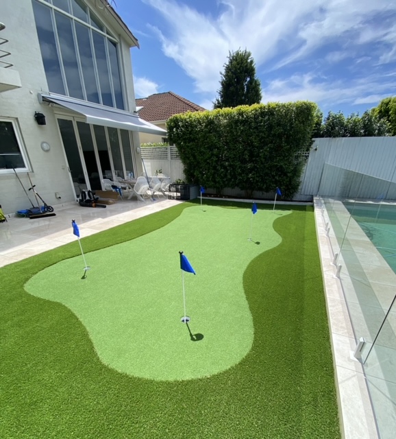 Backyard golf putting green with flags.