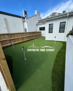 A small backyard with synthetic turf and mini golf putting holes.