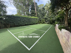 A freshly installed synthetic turf court surrounded by greenery.