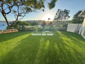 A vibrant backyard with lush green synthetic turf under a clear sky.
