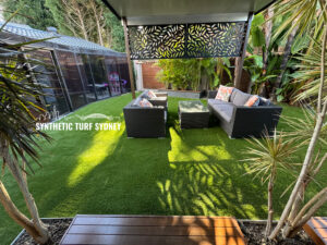 Cozy outdoor seating area on vibrant artificial turf beneath a decorative canopy.